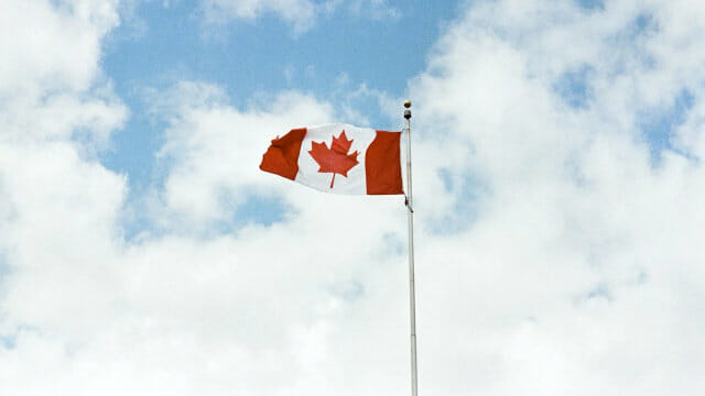 canada-flag-cloudy-sky-jp-valery-unsplash